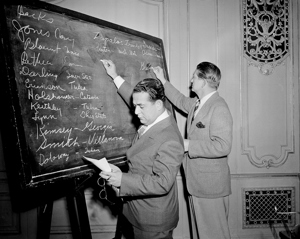Fred Mandel, president of the Detroit Lions, and Charles Walsh, assistant coach of the Cleveland Rams, look over prospects at the NFL player draft in 1943.