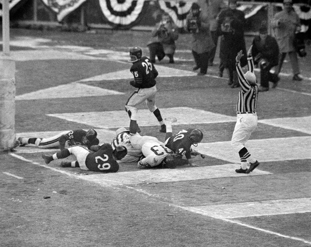 El segundo &#xE1;rbitro Sam Wilson hace las se&#xF1;ales de una anotaci&#xF3;n en el partido por el campeonato de la NFL de 1956 entre los Chicago Bears y los New York Giants. (Fotograf&#xED;a AP/Harry Harris)