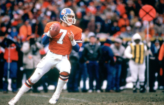 Former Denver Broncos quarterback John Elway passes the football.